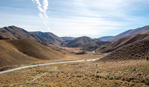 Barren mountain landscape with tufts of grass, pass road