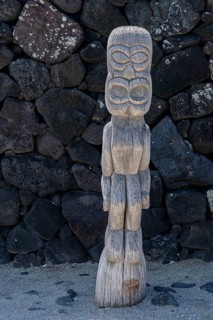 Wooden guardian figure Tiki in front of lava stone wall, Pu'uhonua O Honaunau National Historical Park