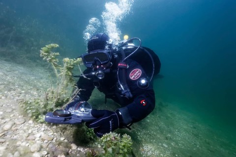 Divers in dry suits orientate themselves with compass in waters with poor visibility, Echinger Weiher