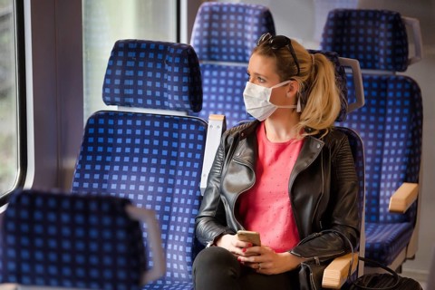 Woman with a face mask, sitting in Zug