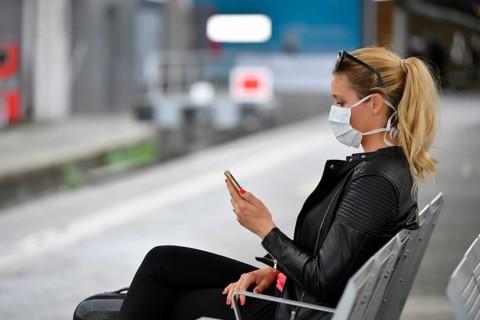 Woman with face mask, waiting for train