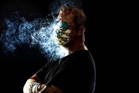 Man with face mask smoking cigarette