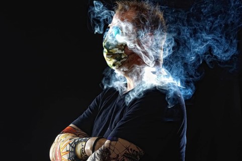 Man with face mask smoking cigarette