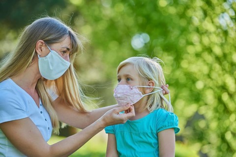 Mother ties daughter face mask