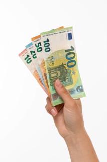 Woman holding fanned euro banknotes in her hand