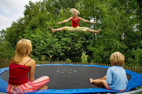 Girls jumping on the trampoline in the garden