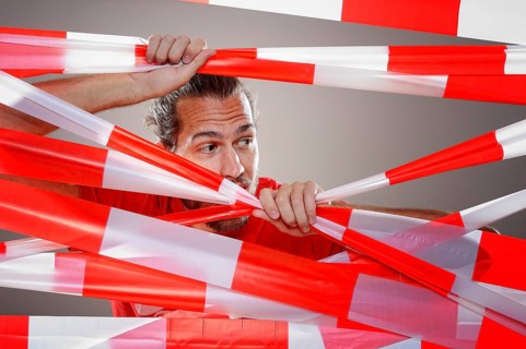 Young man with barrier tape in red and white