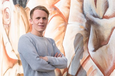 Young man in front of graffiti wall