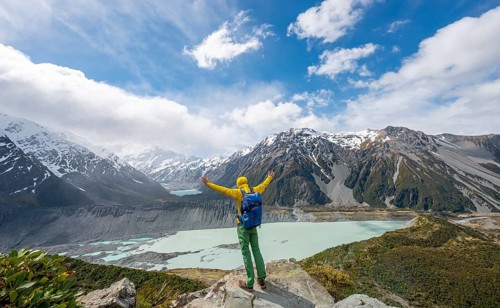 Hiker stretches his arms in the air