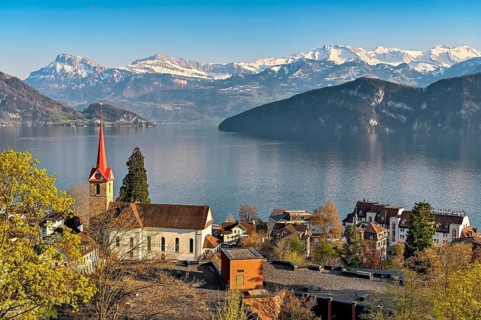 Holiday destination on Lake Lucerne with the parish church of St. Mary behind the snow-covered Alps