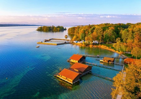 Boathouses and Rose Island in Lake Starnberg near Feldafing in the morning light