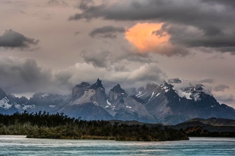 View over the river Rio Serrano to the mountain range Cuernos del Paine with cloudy sky