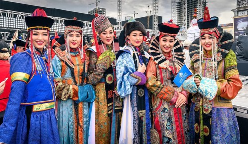Beautiful young ladies staying in Mongolian traditional costumes of different ethnic groups in the central square