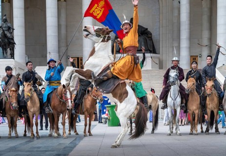 Young horse rider man a rising horse in front of the Parliament house during NAADAM festival