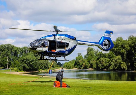 Police helicopter Airbus H 145 during exercise with fire water tank BAMBI BUCKET