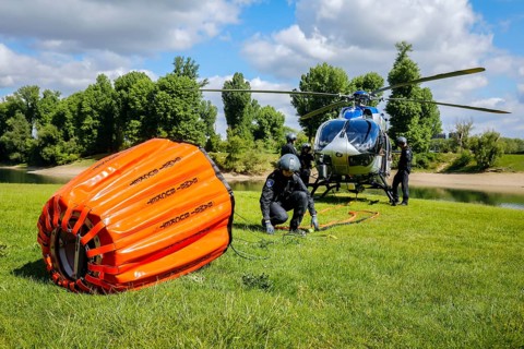 Police helicopter Airbus H 145 during exercise with fire water tank BAMBI BUCKET