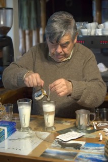 Shopkeeper brewing and serving cappuccino