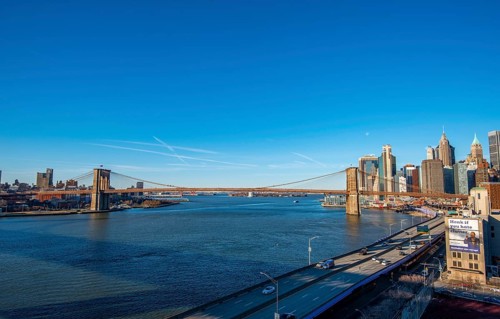 View from Manhattan Bridge over the East River to the skyline of Lower Manhattan and Brooklyn Bridge