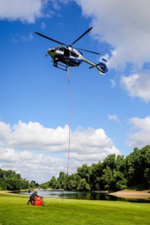 Police helicopter Airbus H 145 during exercise with fire water tank BAMBI BUCKET