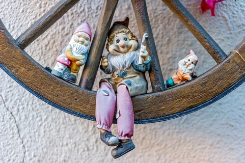 Garden gnomes in wooden wagon wheel