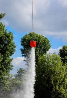 Police helicopter during exercise with fire water tank BAMBI BUCKET