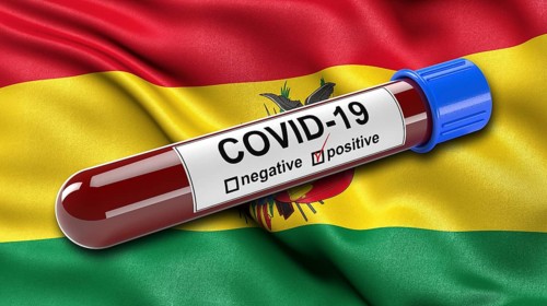 Flag of Bolivia waving in the wind with a positive Covid-19 blood tube