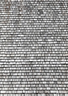 Facade of a wooden house with weathered wooden shingles