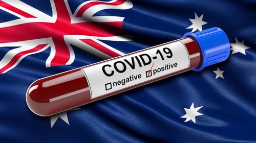 Flag of Australia waving in the wind with a positive Covid-19 blood tube