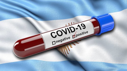 Flag of Argentina waving in the wind with a positive Covid-19 blood tube