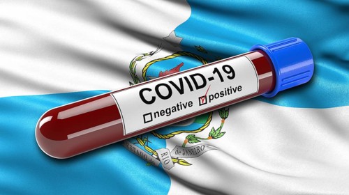 Flag of Rio de Janeiro waving in the wind with a positive Covid-19 blood tube