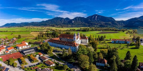 Aerial view of Schlehdorf Monastery with St. Tertulin Parish Church at Lake Lake Kochel