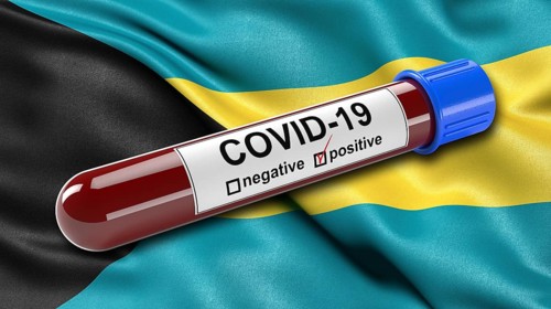 Flag of Bahamas waving in the wind with a positive Covid-19 blood tube