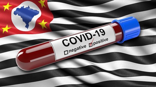 Flag of Sao Paulo waving in the wind with a positive Covid-19 blood tube