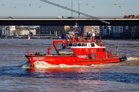 Fireboat navigates on the Rhine during floods under the Rhine knee bridge