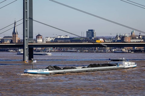 Freighters navigating at high water on the Rhine under the Rheinkniebruecke