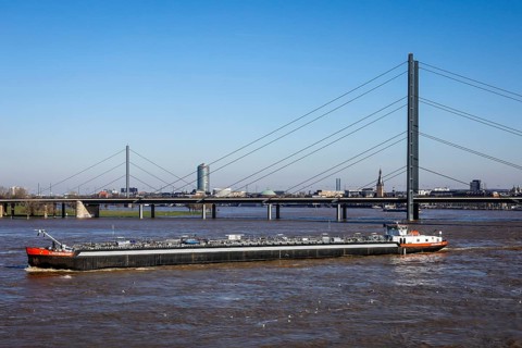 Freighters navigating at high water on the Rhine under the Rheinkniebruecke