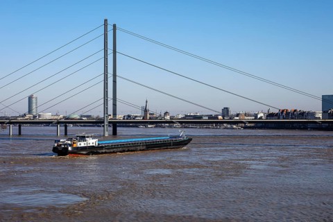 Freighters navigating at high water on the Rhine under the Rheinkniebruecke