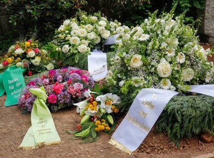 Mourning wreaths with ribbons on a fresh grave