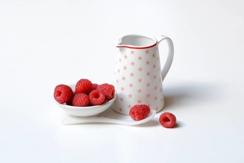 Bowl with raspberries and milk jug