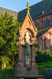 Crucifix in front of the neo-gothic collegiate church of St. John the Baptist