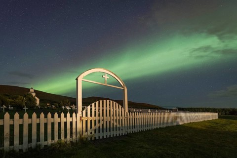 Northern lights over church and cemetery
