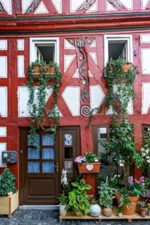 Small historic half-timbered house with painted carvings and flower decorations