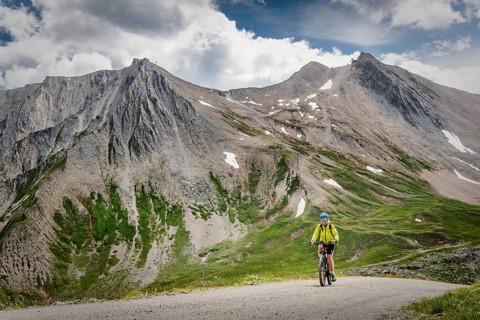 Mountain biker rides on alpine gravel road