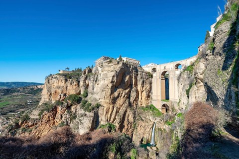 Bridge Puente Nuevo with waterfall at steep cliffs