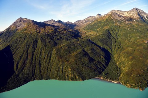 Steep forested mountainsides and an emerald green lake