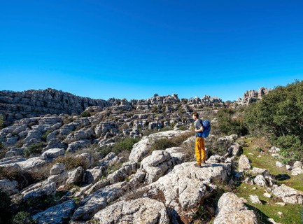 Young man standing on rocks and looking into the distance