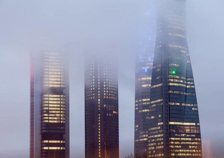 Cuatro Torres Business Area Office building illuminated in evening fog