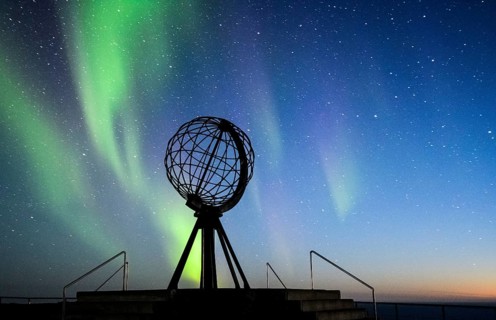 Steel globe at North Cape with northern lights