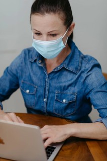 Woman with mouth guard on laptop
