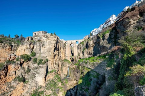 Bridge Puente Nuevo with waterfall at steep cliffs